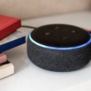 Enceinte connectée noire posée près de livres