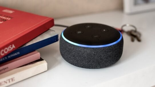 Enceinte connectée noire posée près de livres