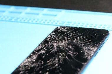 The smartphone's screen is badly cracked.