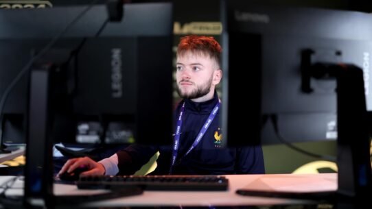 Joueur concentré devant deux écrans lors d'une compétition de jeux vidéo