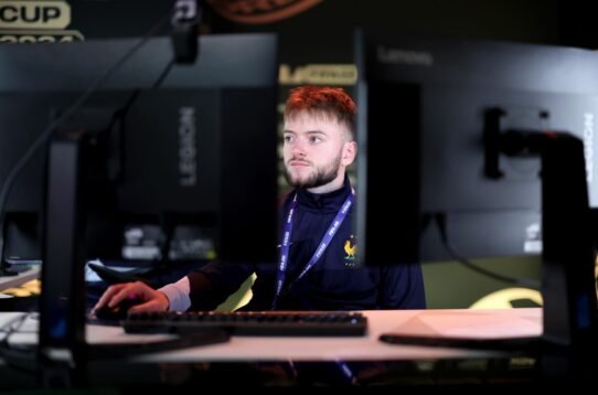 Joueur concentré devant deux écrans lors d'une compétition de jeux vidéo