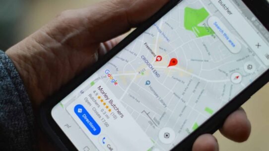 Main tenant un smartphone avec Google Maps affiché