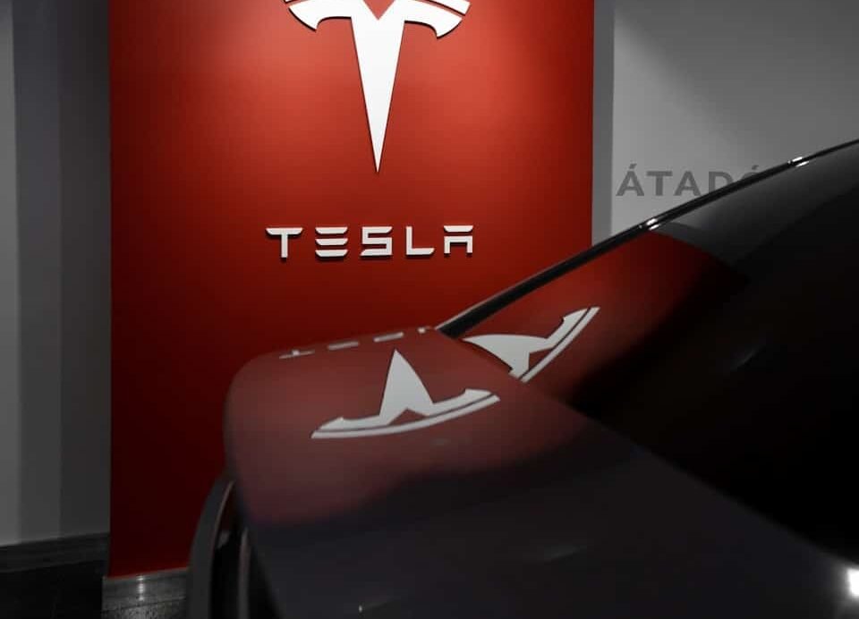 Logo Tesla blanc sur fond rouge dans un showroom