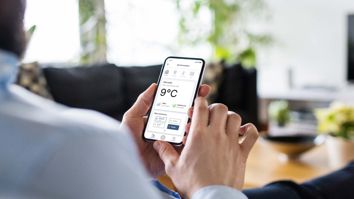 Personne utilisant une application domotique sur smartphone