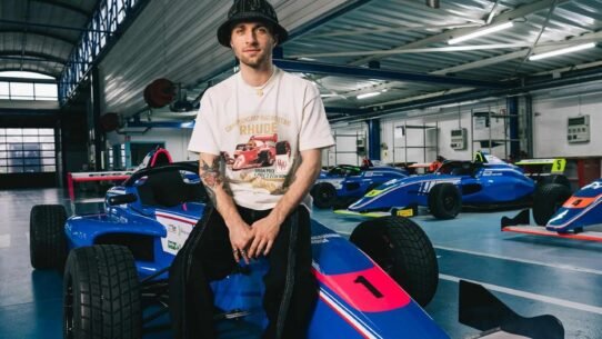 Homme assis sur une voiture de course dans un garage