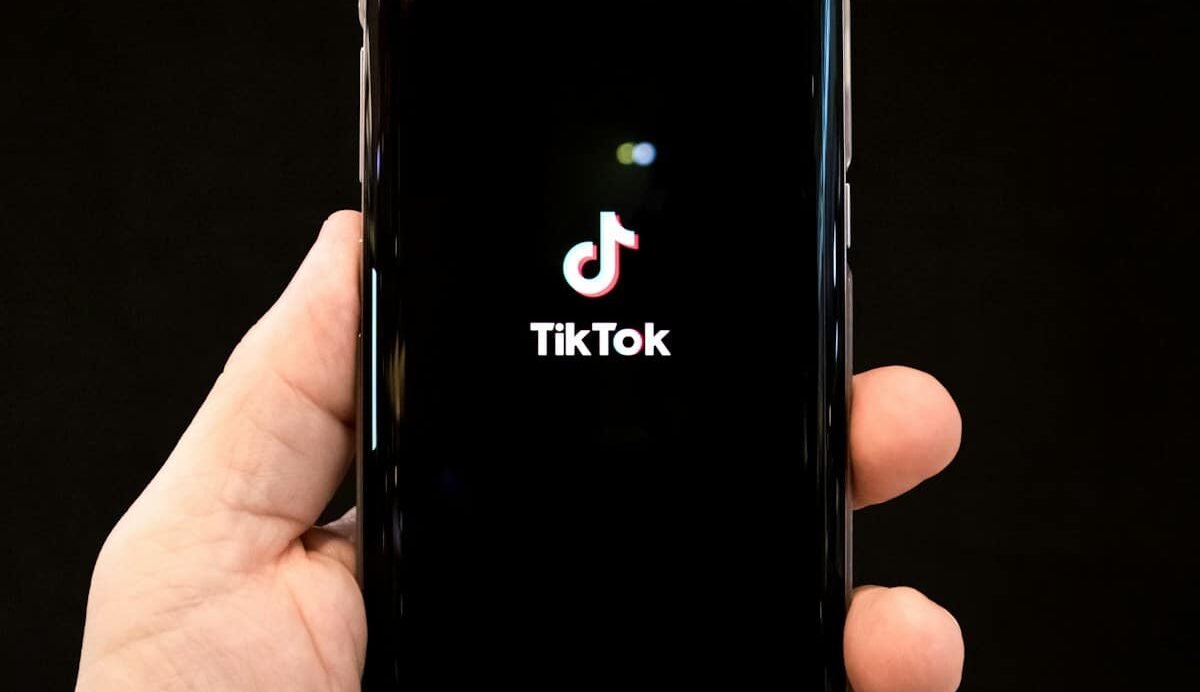 Main tenant un smartphone avec l'application TikTok ouverte