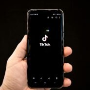 Main tenant un smartphone avec l'application TikTok ouverte