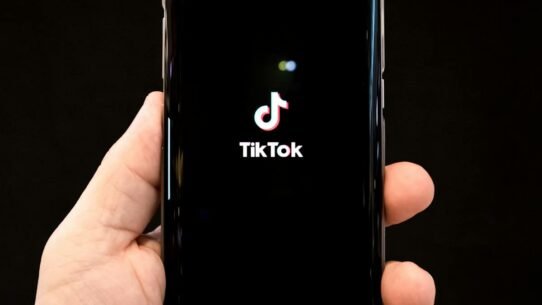 Main tenant un smartphone avec l'application TikTok ouverte
