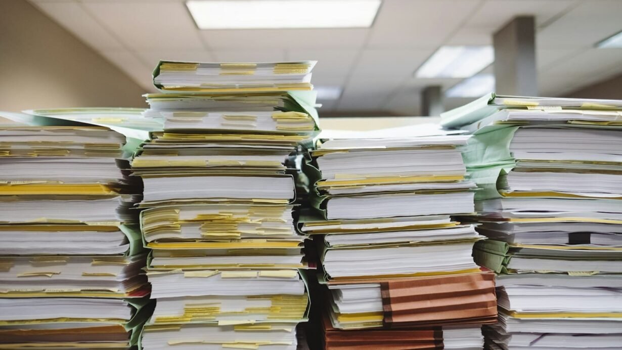 Piles de dossiers et documents sur un bureau