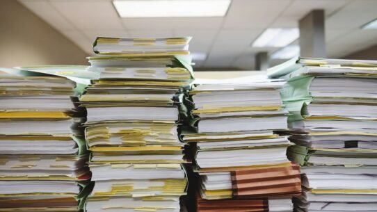Piles de dossiers et documents sur un bureau