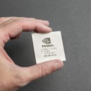 Processeur Nvidia tenu entre les doigts sur fond gris