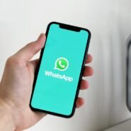 Main tenant un smartphone avec l'application WhatsApp ouverte