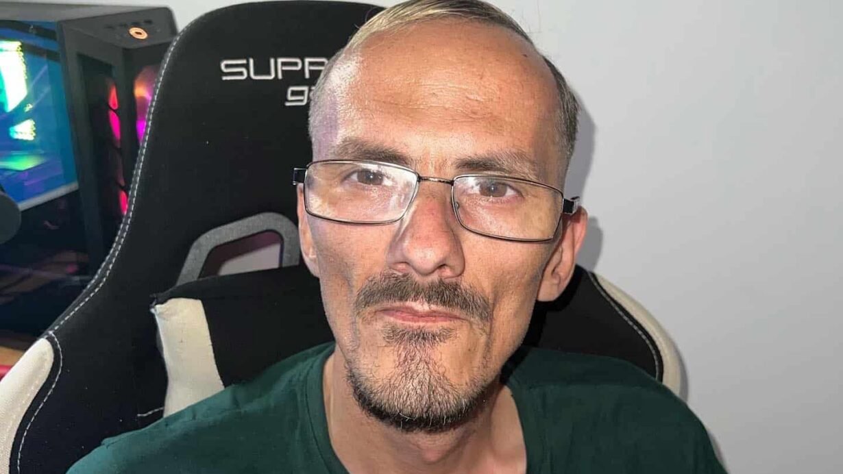 Homme portant des lunettes assis sur une chaise gaming