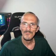 Homme portant des lunettes assis sur une chaise gaming