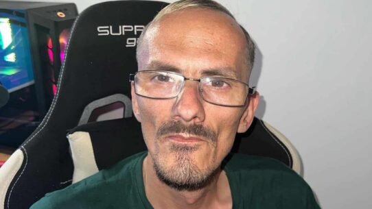 Homme portant des lunettes assis sur une chaise gaming