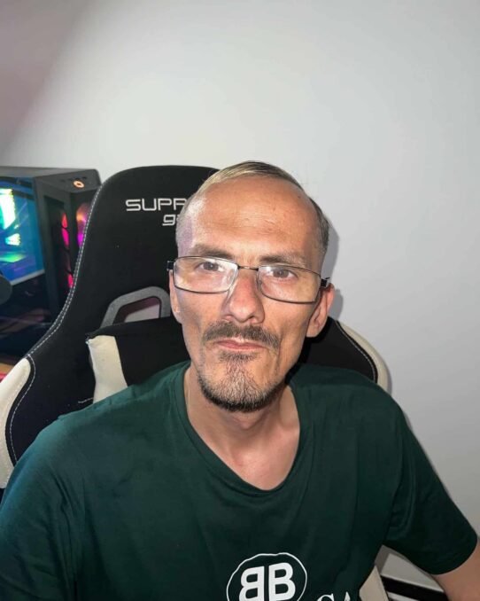 Homme portant des lunettes assis sur une chaise gaming