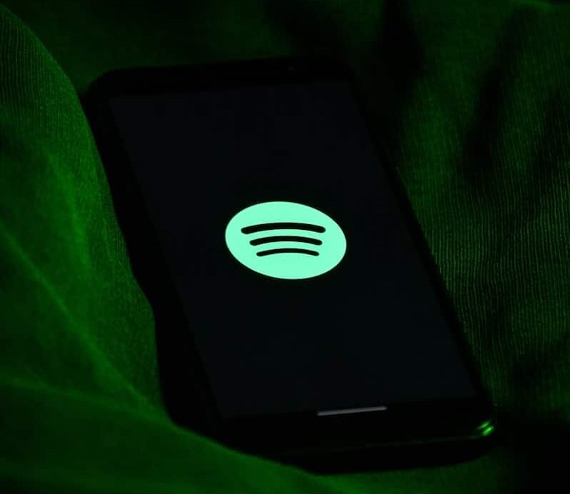 Logo vert sur un smartphone en fond sombre