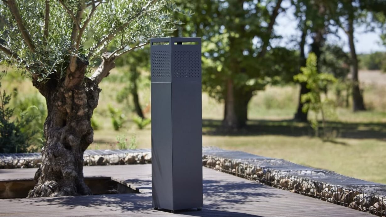 Colonne métallique moderne dans un jardin avec des arbres