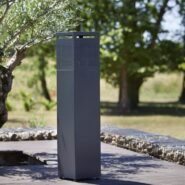 Colonne métallique moderne dans un jardin avec des arbres