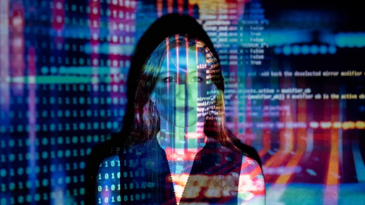 Femme avec des projections de code informatique coloré sur le visage