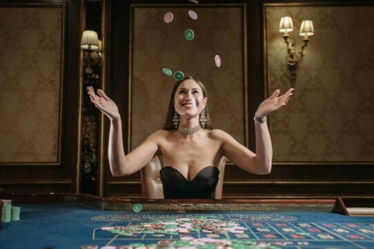 Femme souriante lançant des jetons de casino en l'air