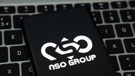 Logo NSO Group affiché sur un smartphone devant un clavier
