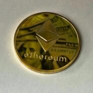 Pièce Ethereum dorée posée sur un billet de banque