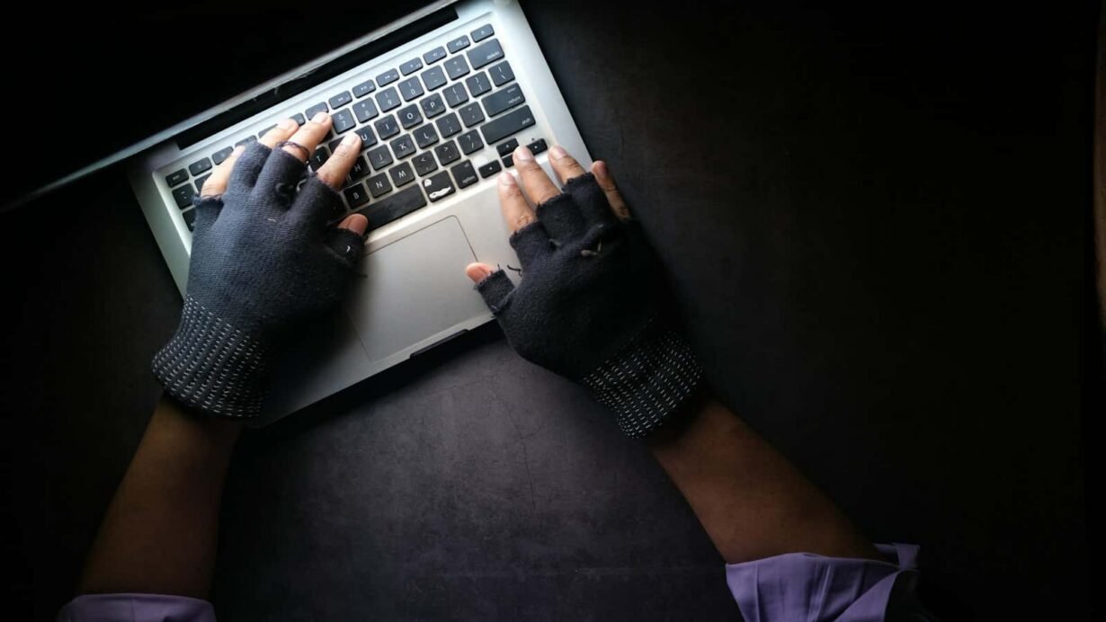 Mains avec gants sur un clavier d'ordinateur portable