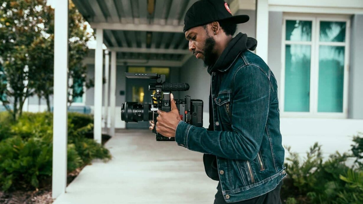 Vidéaste tenant une caméra professionnelle en extérieur