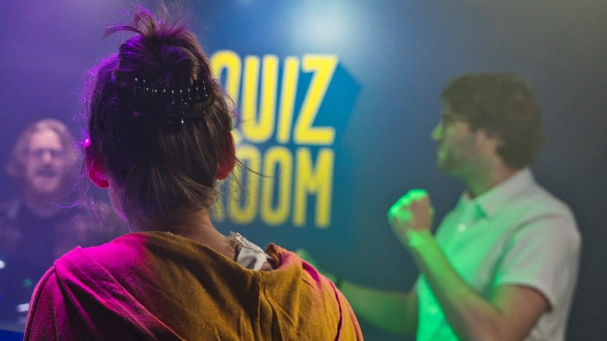 Personnes participant à un jeu de quiz dans une salle éclairée