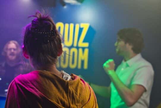 Personnes participant à un jeu de quiz dans une salle éclairée