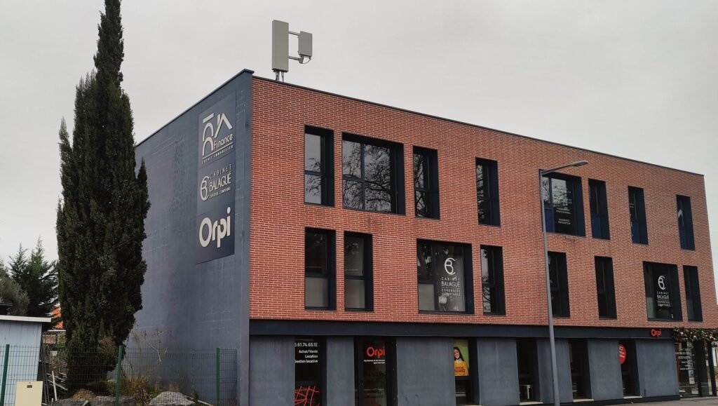 Bâtiment commercial en briques rouges avec panneaux d'enseignes